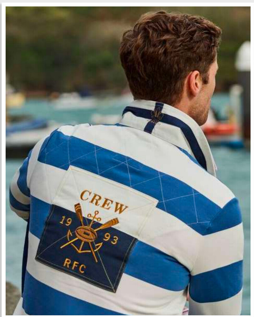 Man seen from behind wearing a blue and white custom rugby shirt with embroidered back artwork